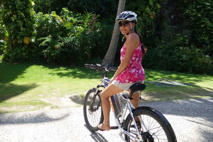 a little girl riding on the back of a bicycle